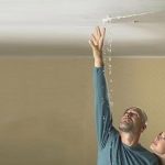 Man and woman inspecting a ceiling leak, addressing water pressure issues with Charles Krull plumbing assistance.