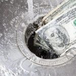 Currency bills going down a drain with water flow, illustrating waste relevant to leak detection by Charles Krull & Son.