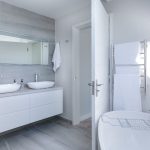 Modern bathroom with double sink vanity, white cabinetry, and minimalist design by Charles Krull & Son, Inc.